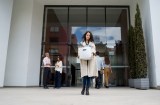 Entlassene Frau verlässt das Bürogebäude mit ihren Habseligkeiten in einer Kiste und sieht traurig aus.