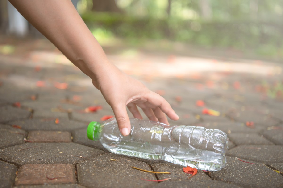 Pfandflasche wird aufgehoben.