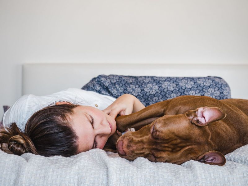 Frau schläft mit Hund