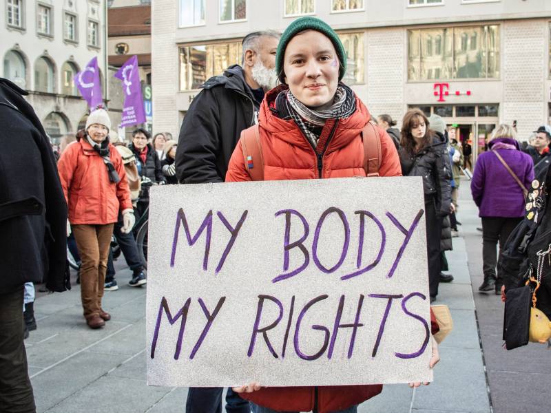 Eine Frau mit feministischem Schild.