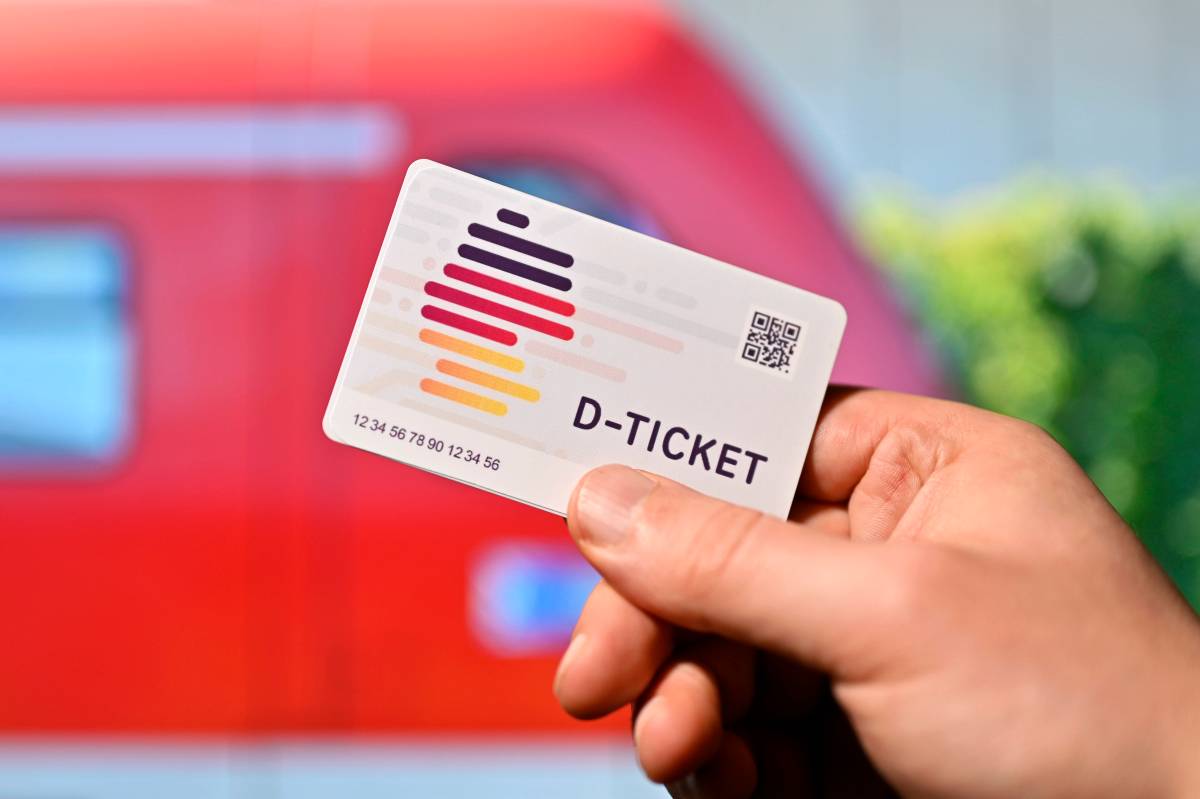 Eine Person hält eine Karte mit der Aufschrift "D-Ticket" in der Hand.