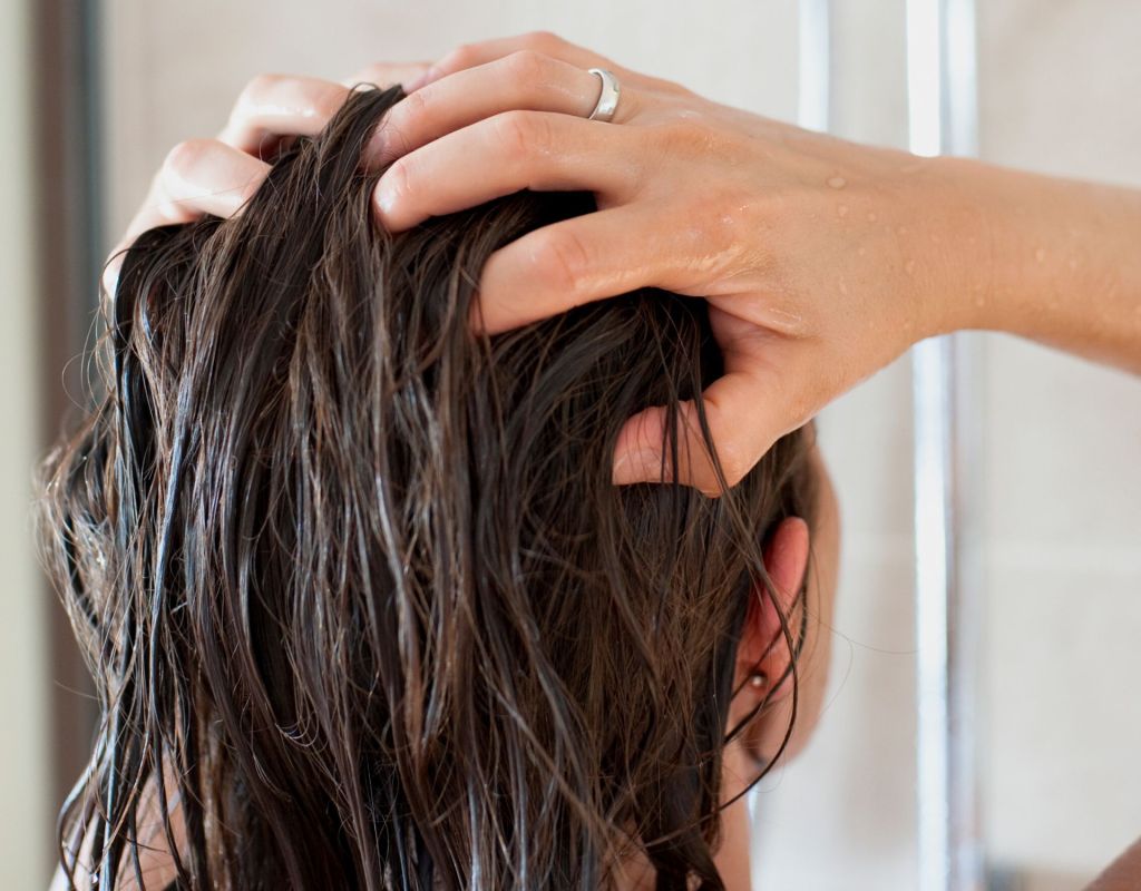 Frau wäscht sich die haare ohne Shampoo
