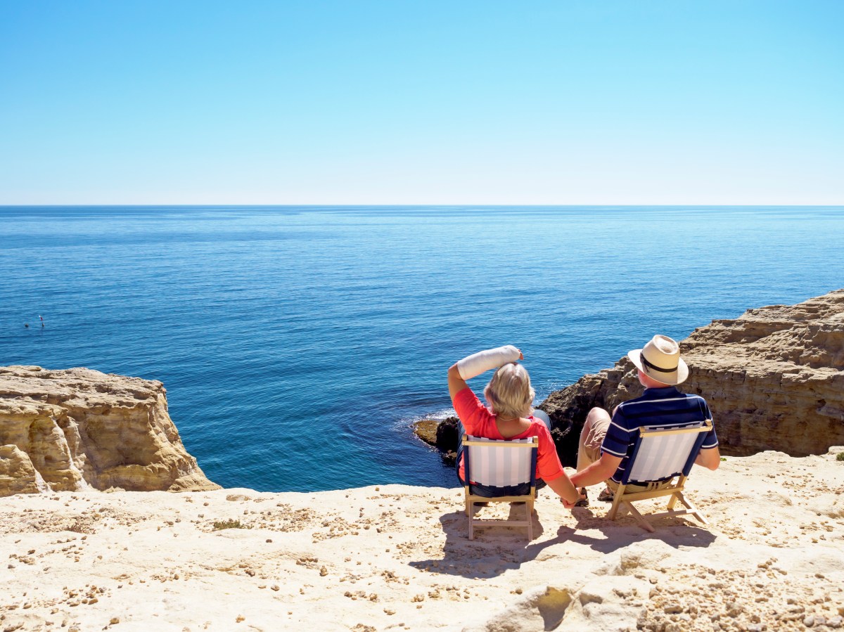 Zwei Senioren sitzen am Meer.