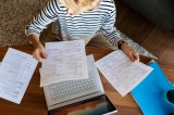 Frau hält sämtliche Dokumente in der Hand.
