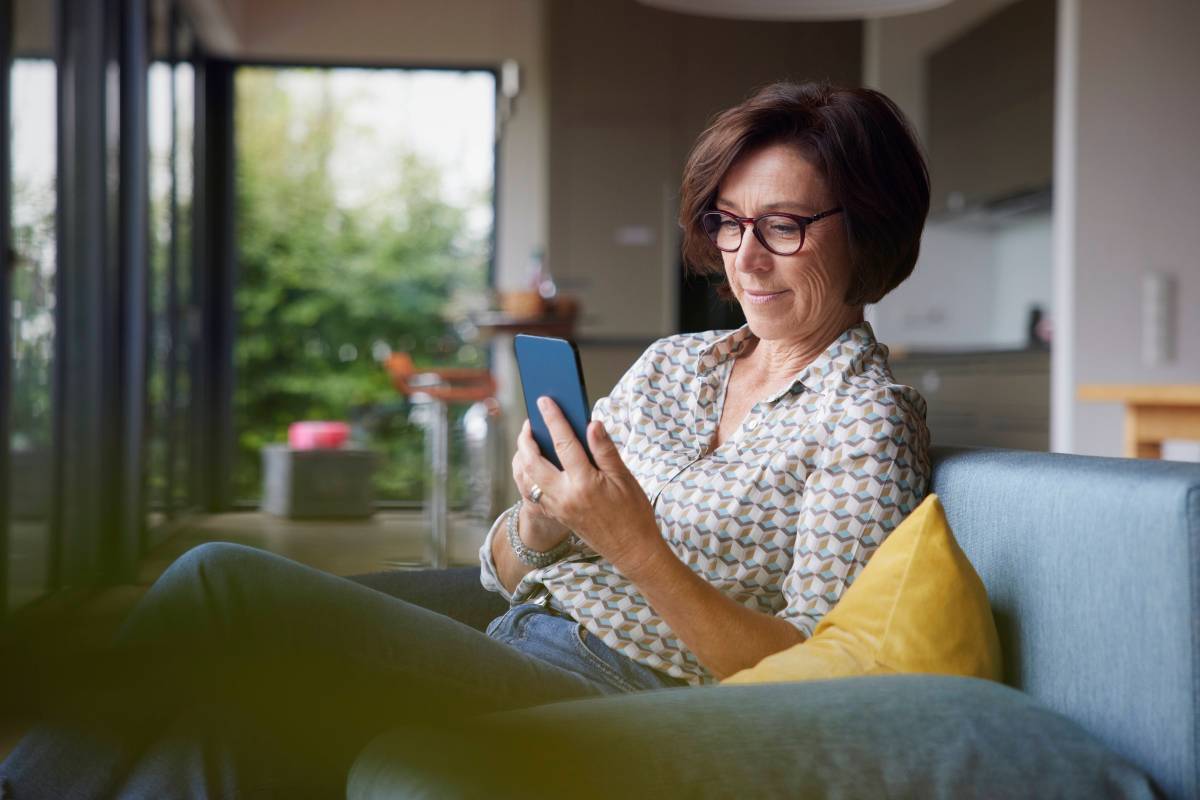 Frau hält Telefon in der Hand.