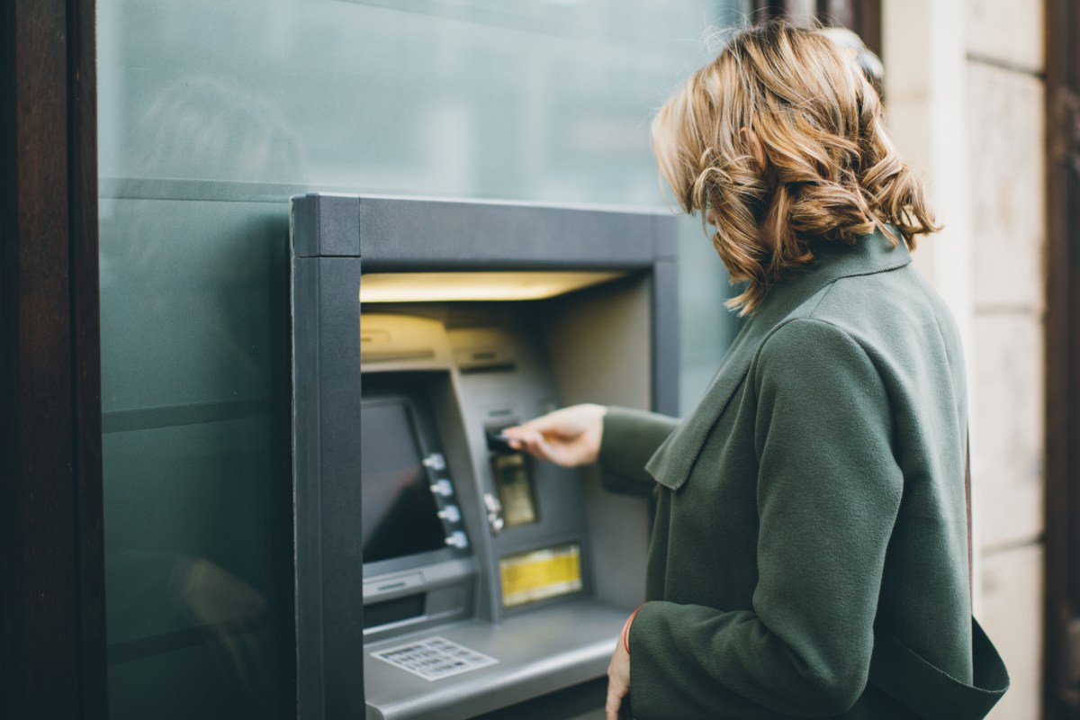 Frau hebt Geld an einem Bankautomaten ab.