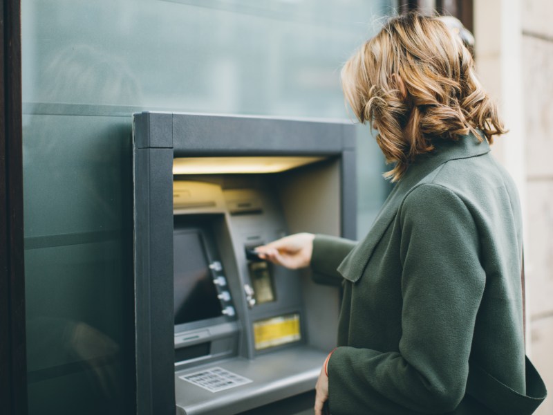 Frau hebt Geld an einem Bankautomaten ab.