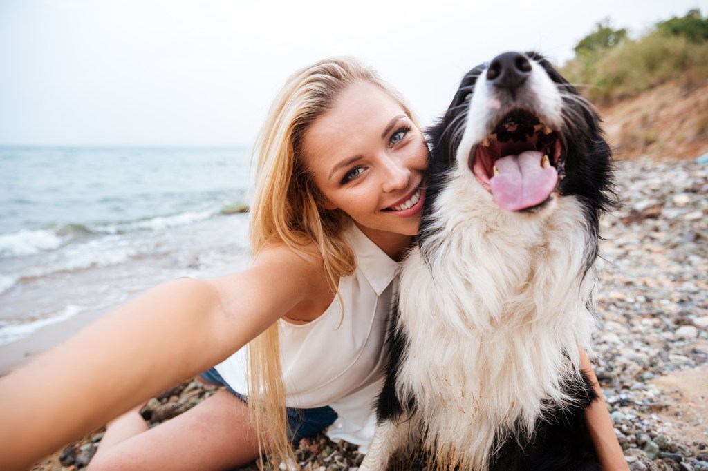 Frau macht Selfie mit einem Hund.