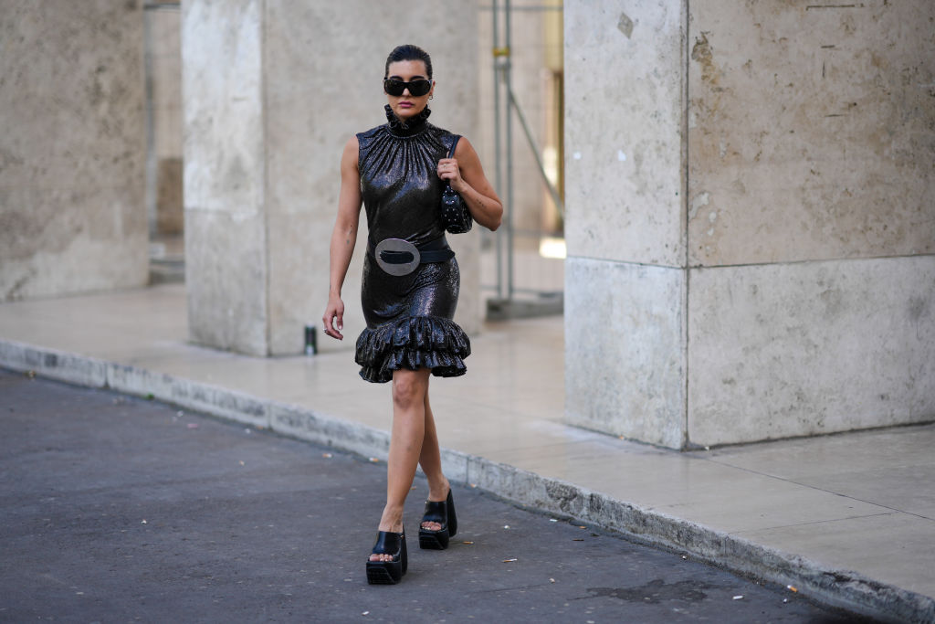Frau mit schwarzen Chunky Sandals und schwarzem Kleid