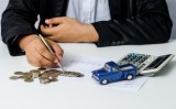 Ein Mann fÃ¼llt seine SteuererklÃ¤rung aus. Neben den Unterlagen liegen MÃ¼nzen und ein Spielzeugauto.