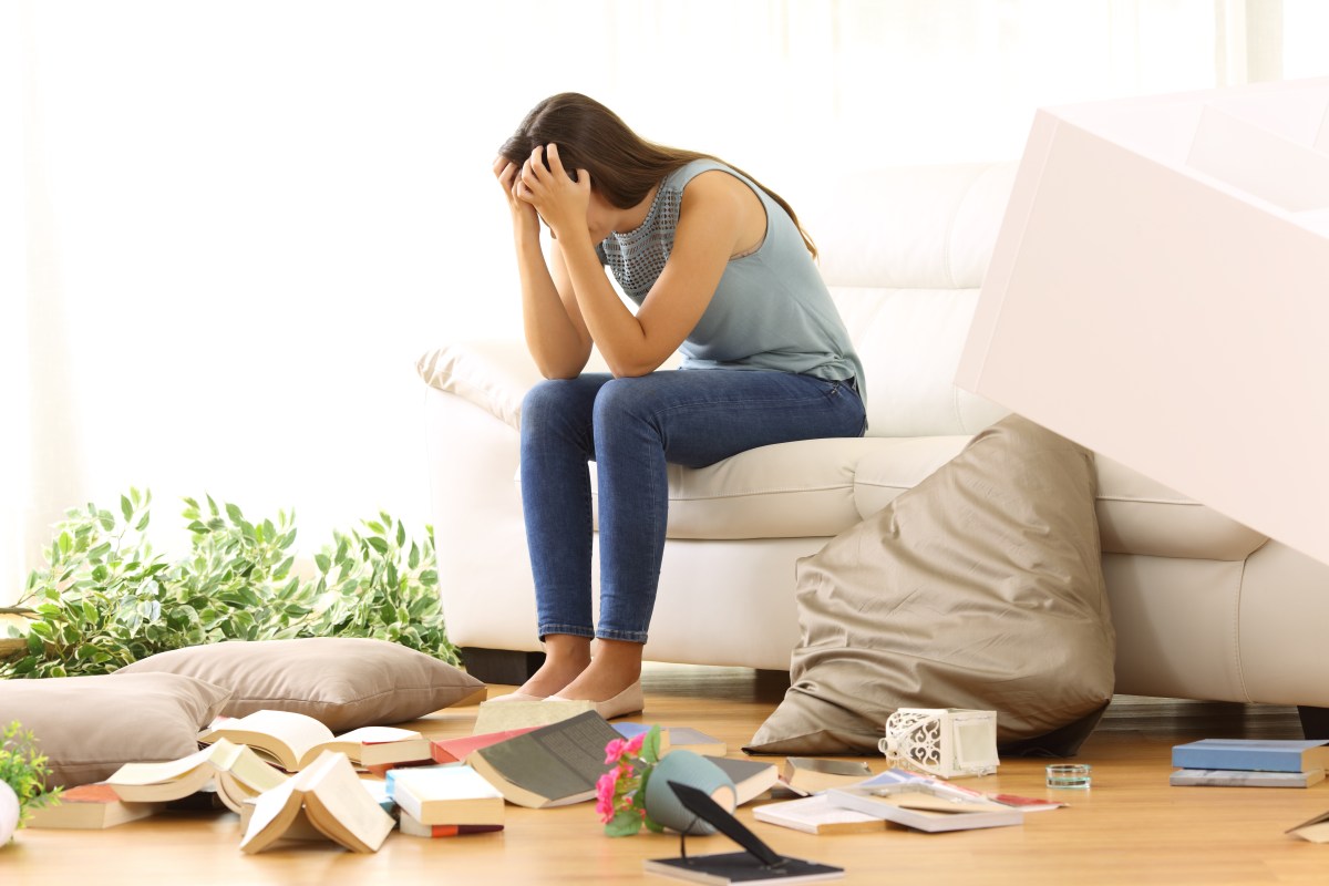 Frau sitzt verzweifelt in ihrer Wohnung. Diese wurde durchwühlt,