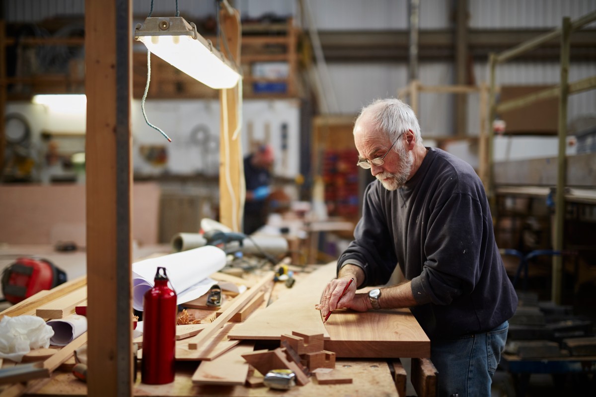 Ein älterer Mann arbeitet in einer Werkstatt.
