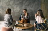 Führungskraft: Drei Geschäftsfrauen unterhalten sich im Büro.