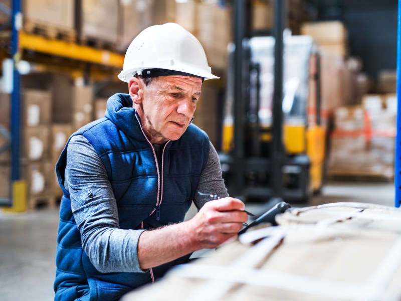 Rentner arbeitet in einer Werkstatt.