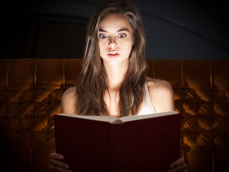 Frau liest ein Buch: Was dein Lieblings-Genre über dich verrät.