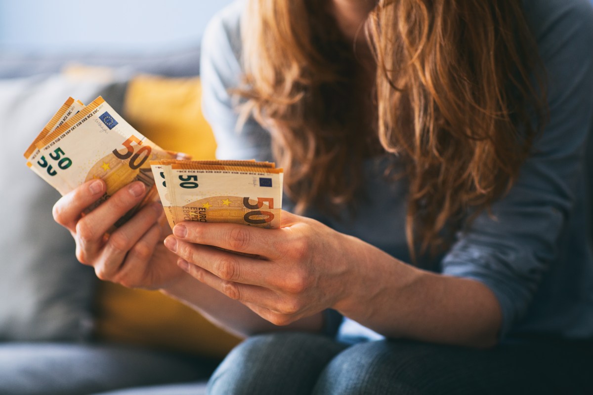 Ein Frau hält mehrere 50-Euro-Scheine in der Hand.