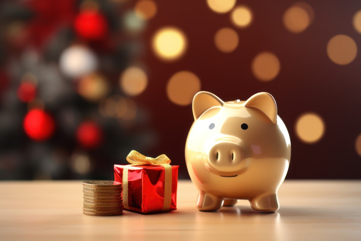 Ein goldenes Sparschwein mit Geld und einem Geschenk vor einem weihnachtlichen Hintergrund.