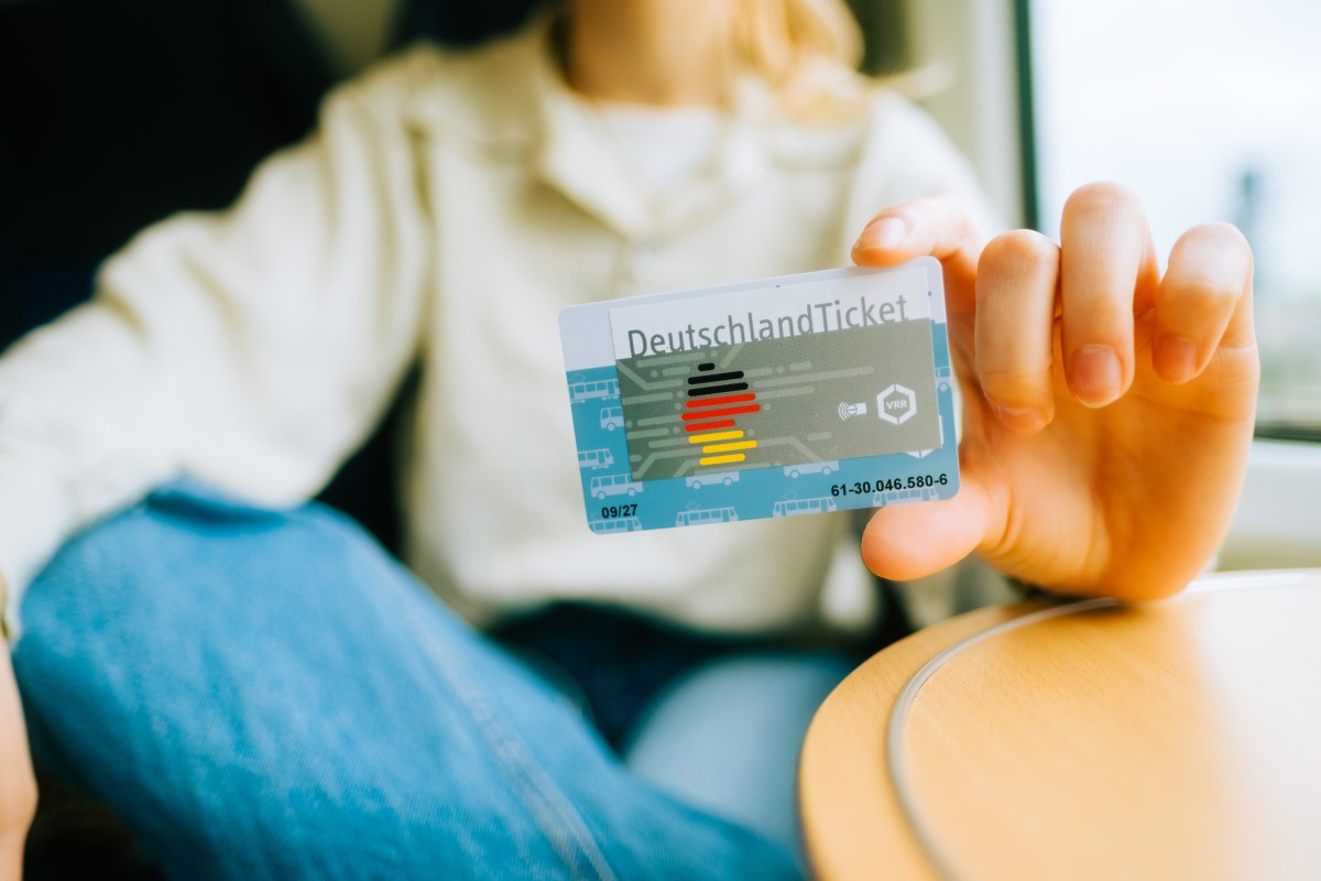 Eine Frau hält das Deutschlandticket in der Hand.