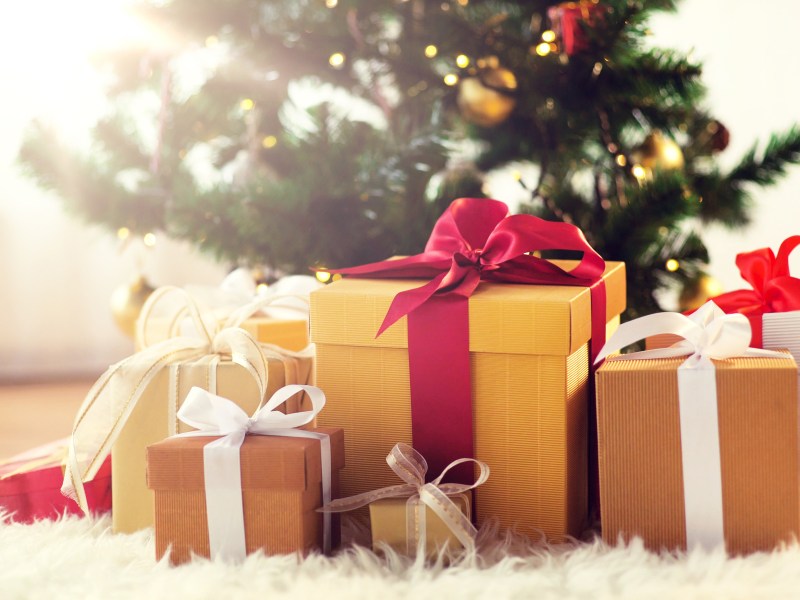 Weihnachtsgeschenke liegen unter einem geschmückten Weihnachtsbaum.