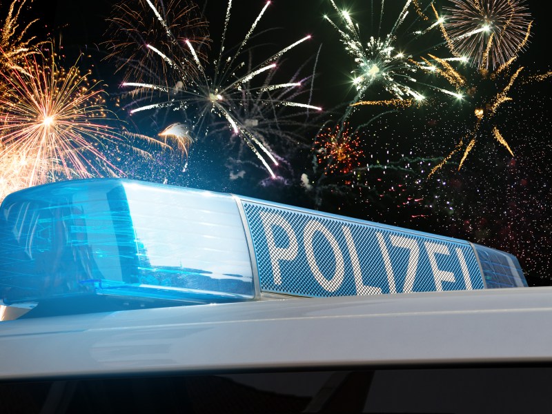 Ein Polizeiauto vor einem Feuerwerk.