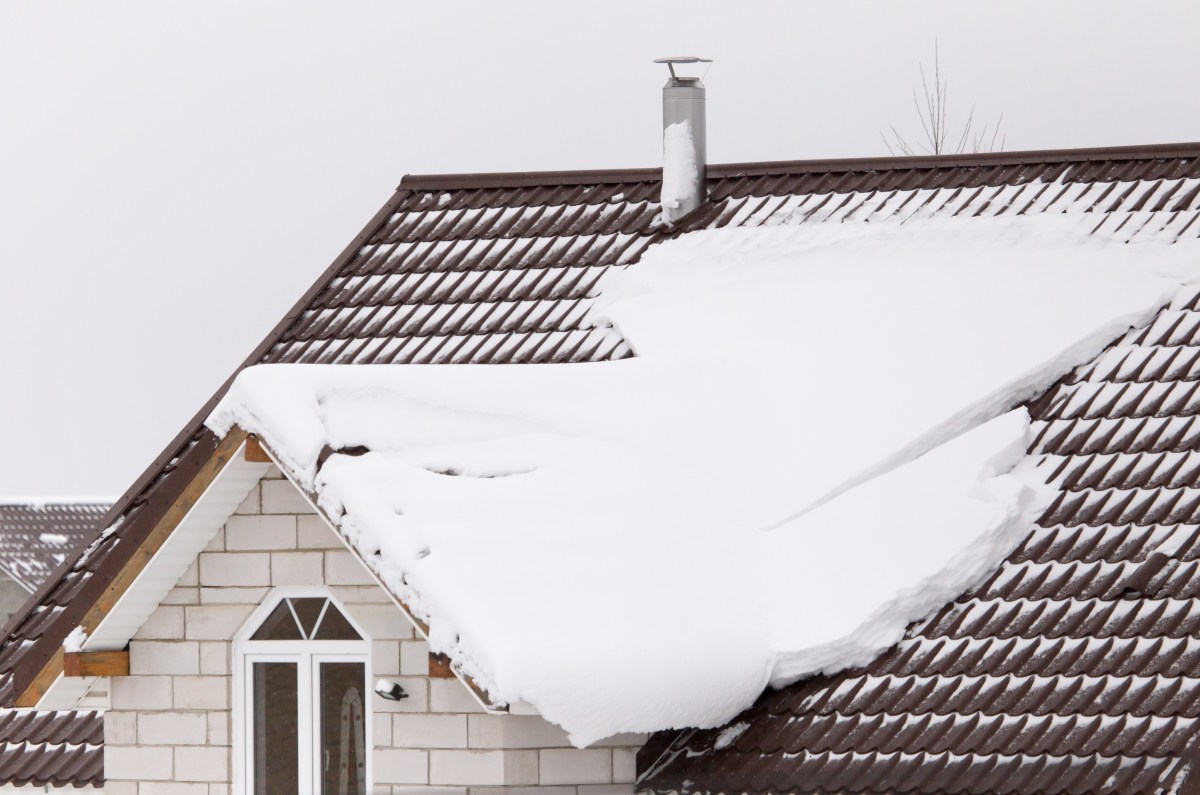 Schnee liegt auf einem Hausdach.