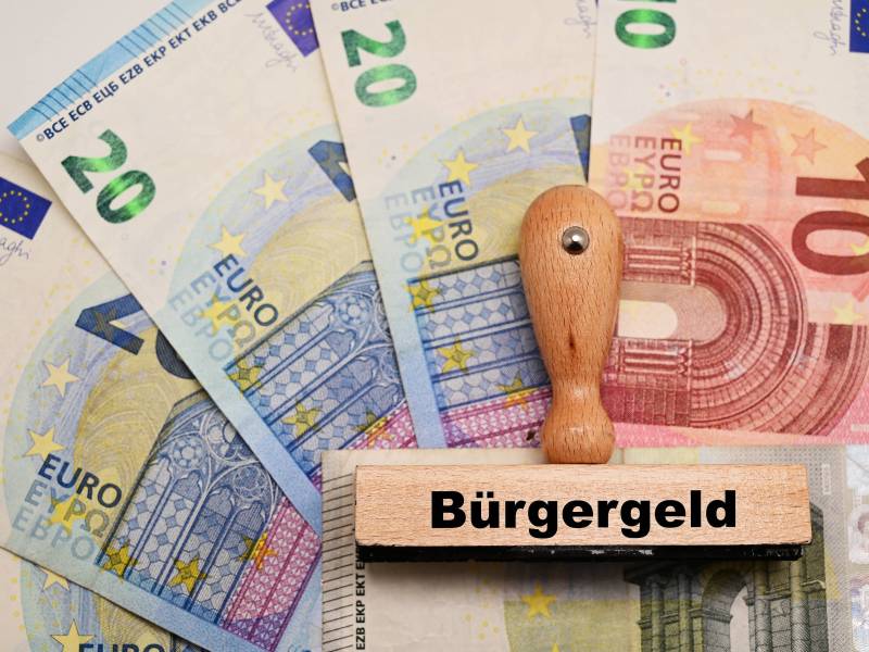 Ein Stempel mit der Aufschrift "Bürgergeld" liegt auf Geldscheinen.