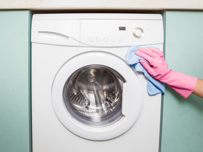 Frau putzt Waschmaschine