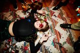 Lachende Frau liegt während einer Weihnachtsfeier auf dem Boden