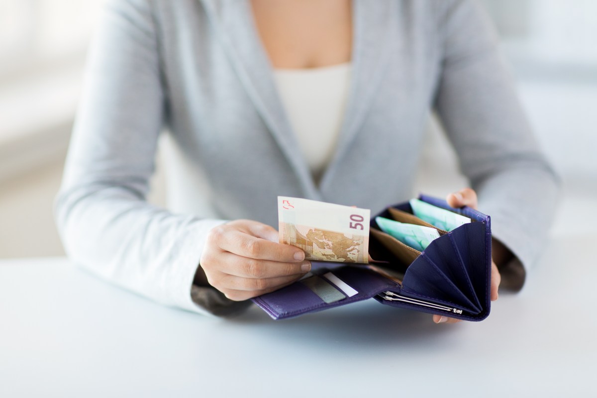 Frau zieht einen 50-Euro-Schein aus dem Portemonnaie.