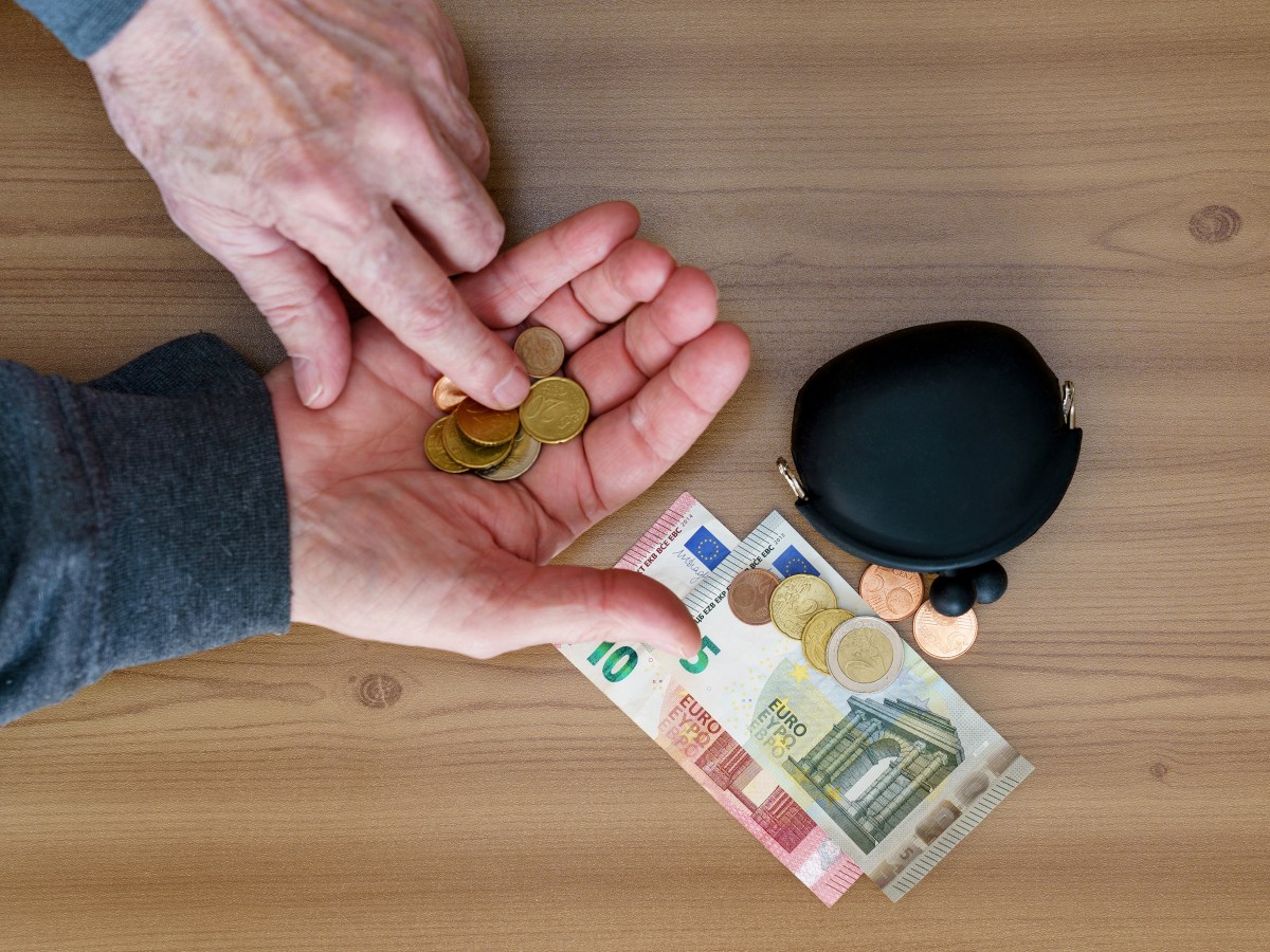 Eine Person zählt Münzen in der Hand.