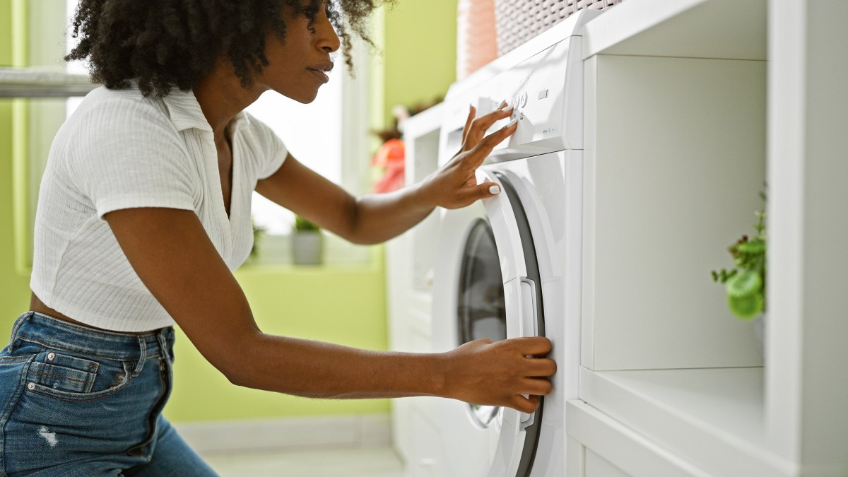 Frau öffnet Waschmaschine