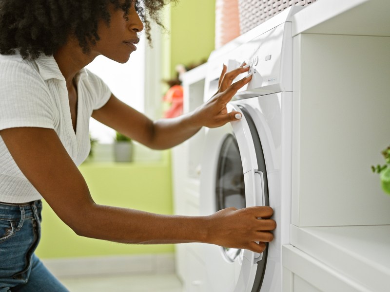 Frau öffnet Waschmaschine