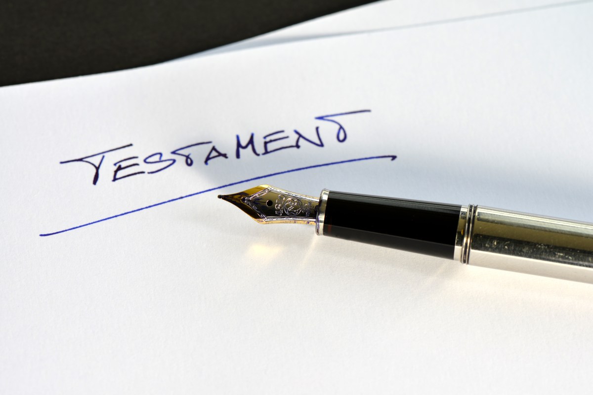 Auf einem Umschlag steht das Wort "Testament". Daneben liegt ein Füller.