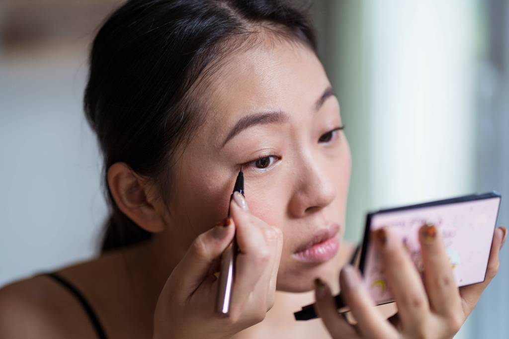 Eine Frau trägt ihren Eyeliner auf.