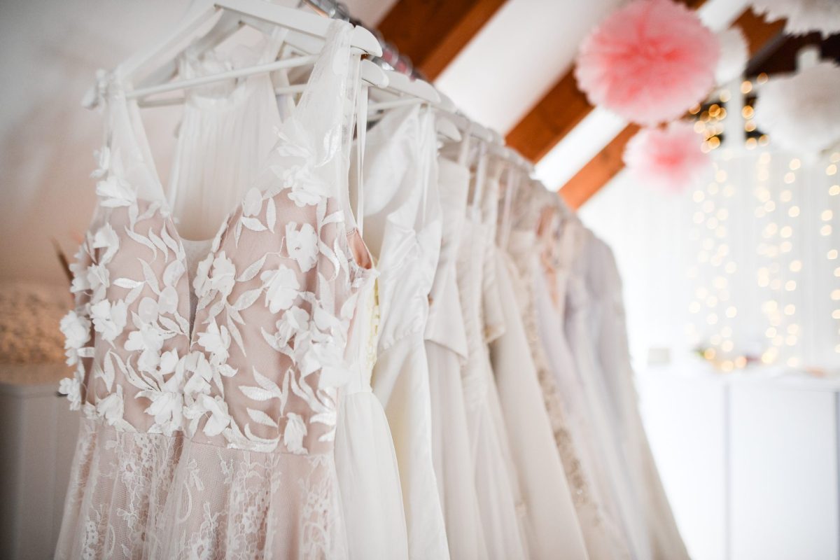 Brautkleider hängen auf einer Stange.