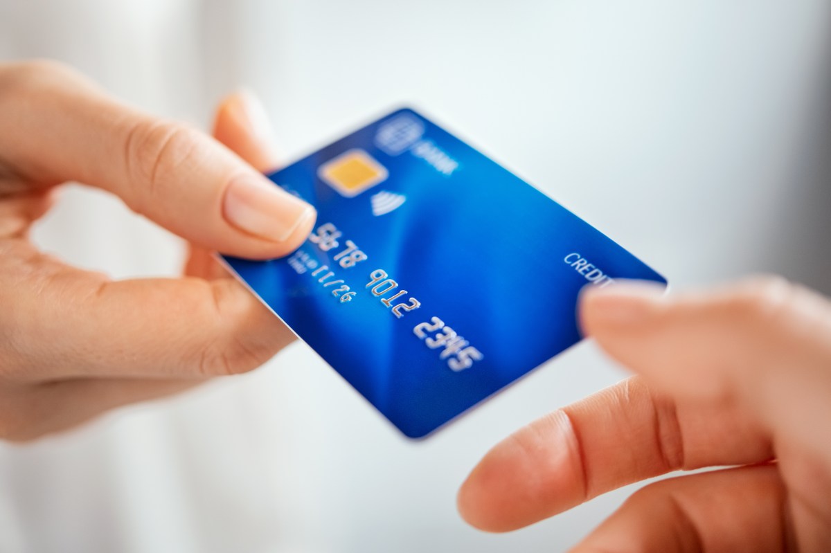 Eine Hand überreicht einer anderen Hand eine Kreditkarte.