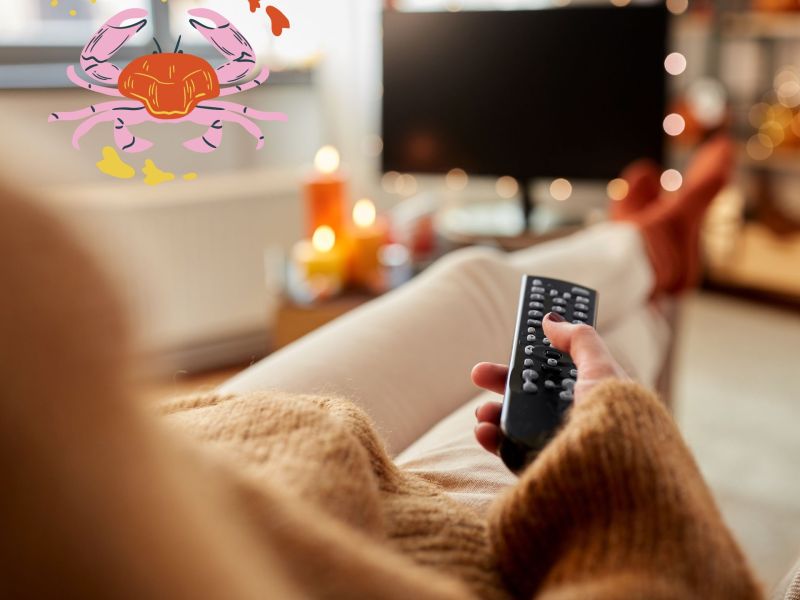 Frau schaut TV auf der Couch: Serien Horoskop für das Sternzeichen Krebs