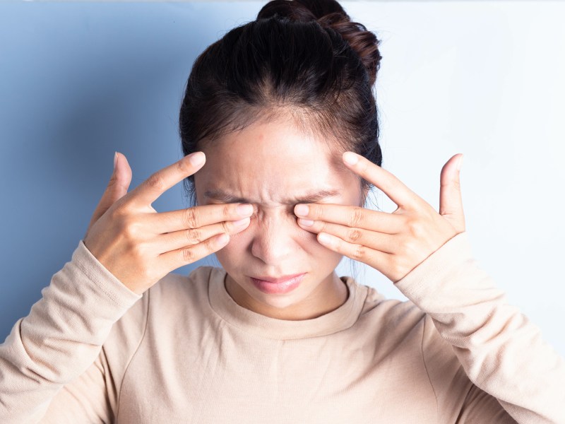 Wimpernverlängerung Allergie Frau reibt sich in den Augen