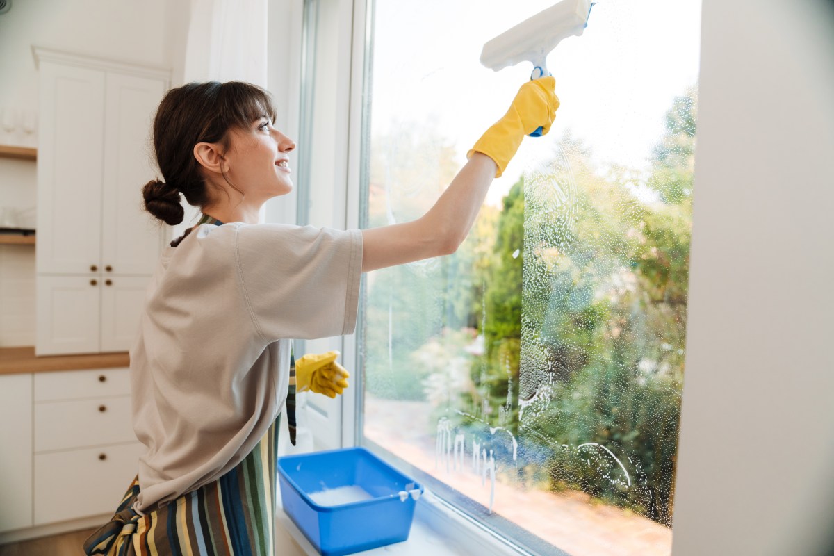 Frau putzt Fenster