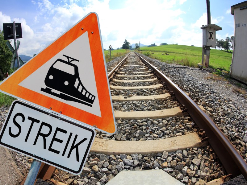 Auf einem Warnschild ist ein Zug abgebildet. Darunter steht das Wort 