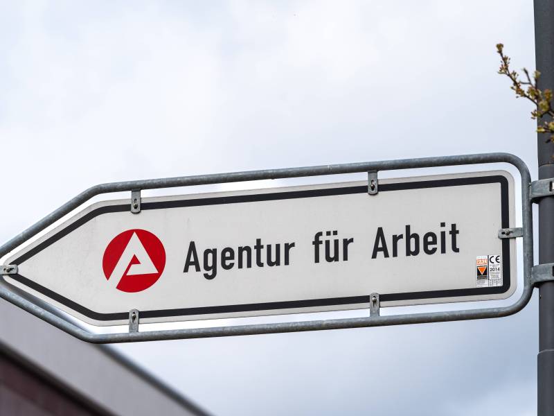 Ein Schild weist den Weg zur Agentur für Arbeit.