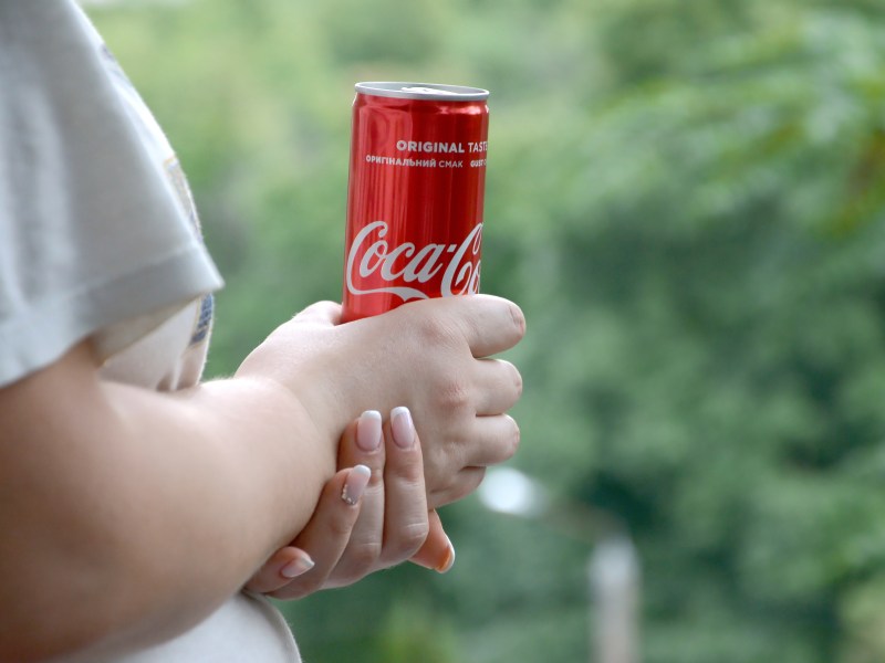 Frau mit Cola im Garten