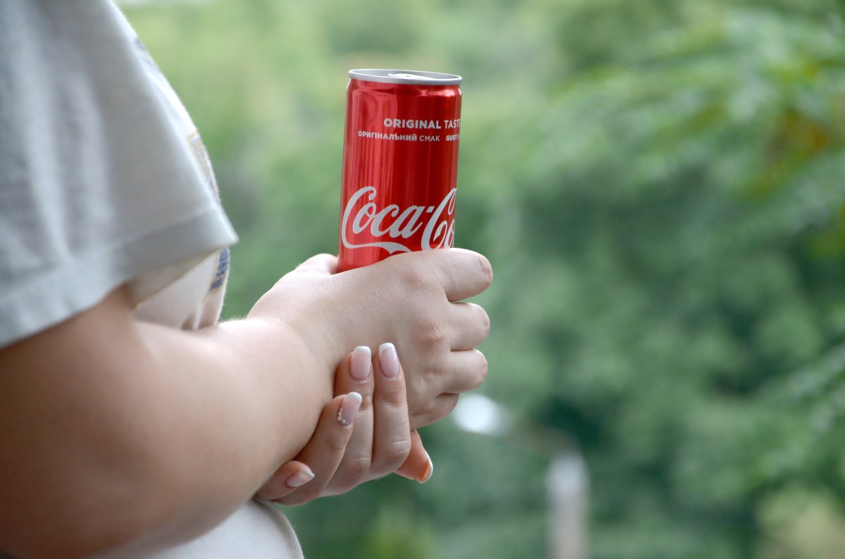 Frau mit Cola im Garten