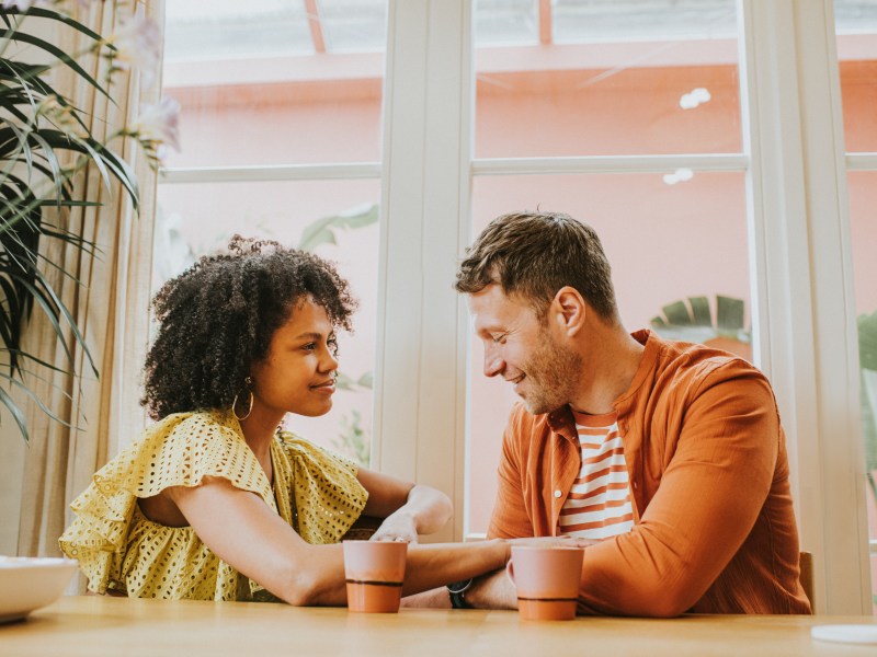 Frau und Mann sitzen sich bei einem Kaffee für ihr erstes Date gegenüber