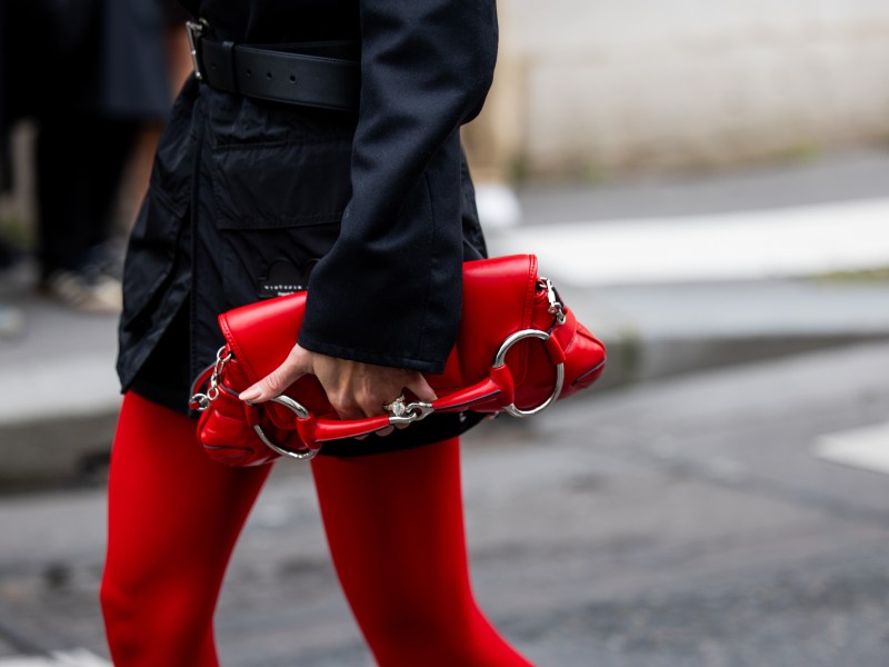 Rote Tasche wird durch die Pariser Straßen getragen.