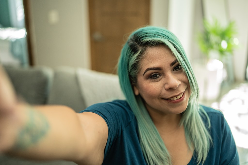 Mittlere erwachsene Frau, die zu Hause ein Selfie macht