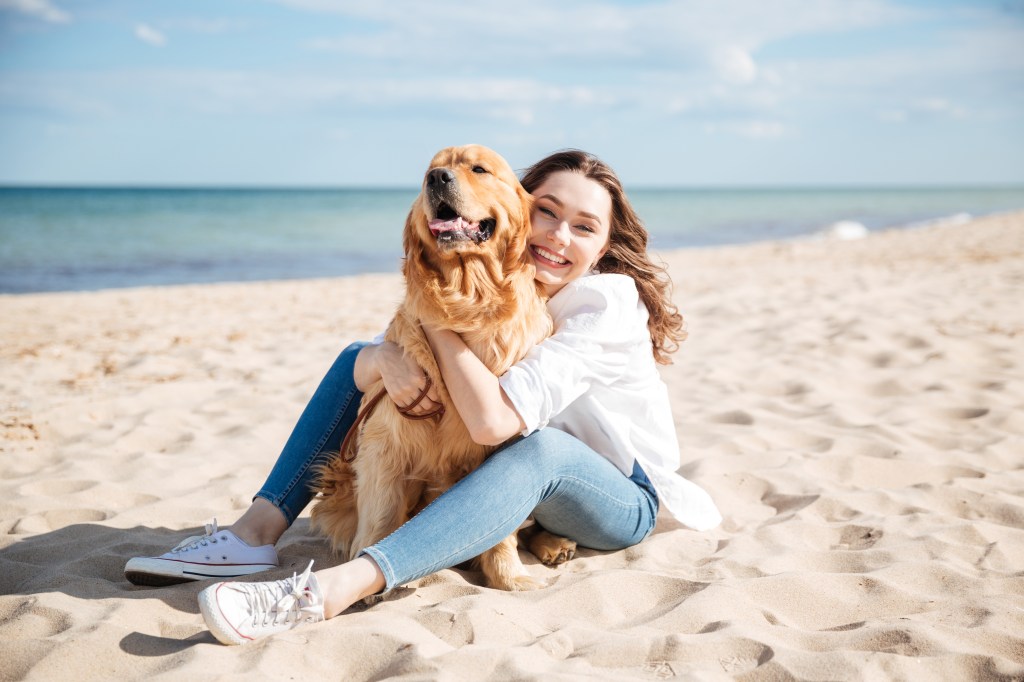 Frau mit Hund am Strand