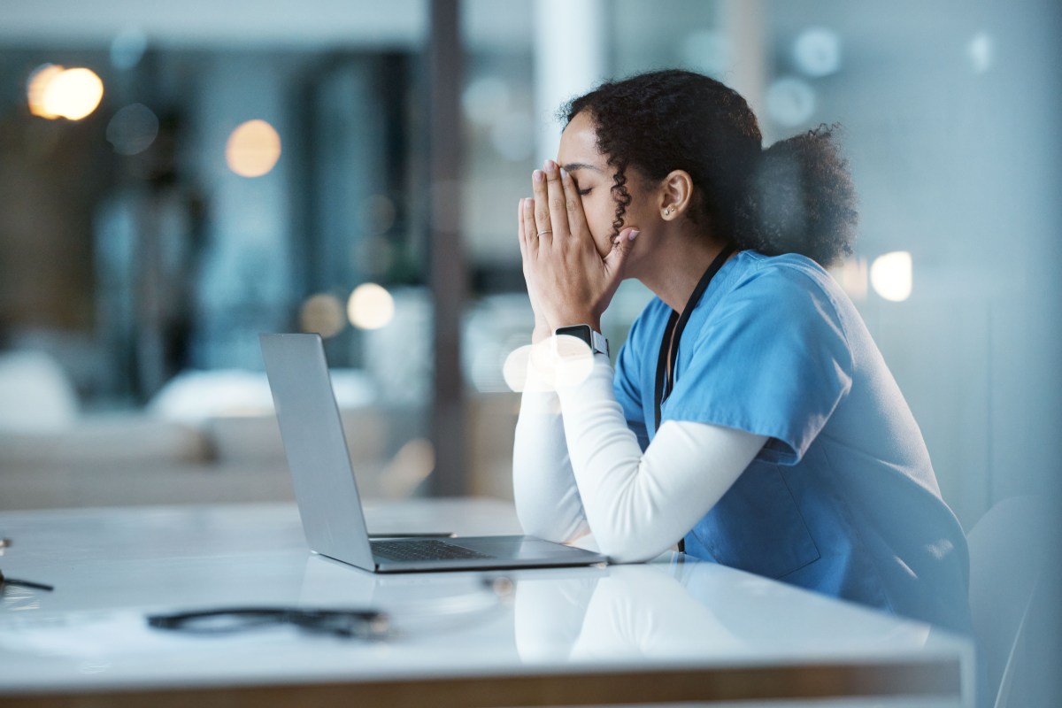 Eine Frau sitzt erschöpft vor ihrem Laptop.