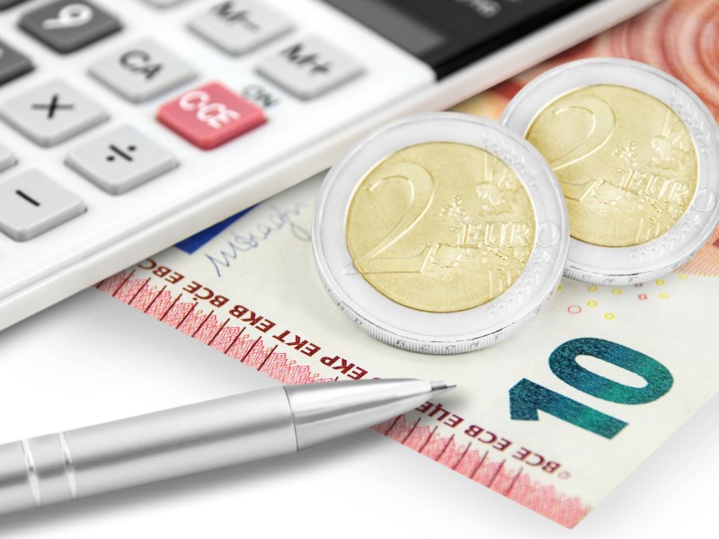 Neben einem Taschenrechner liegt ein zehn Euro schein und zwei 2-Euro-Münzen.