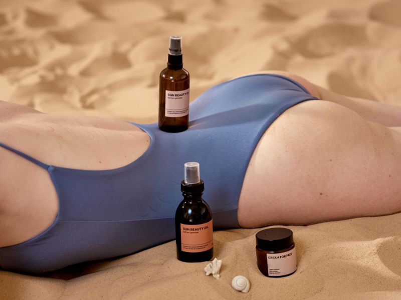 Frau im Bikini mit Sonnenschutz-Produkten